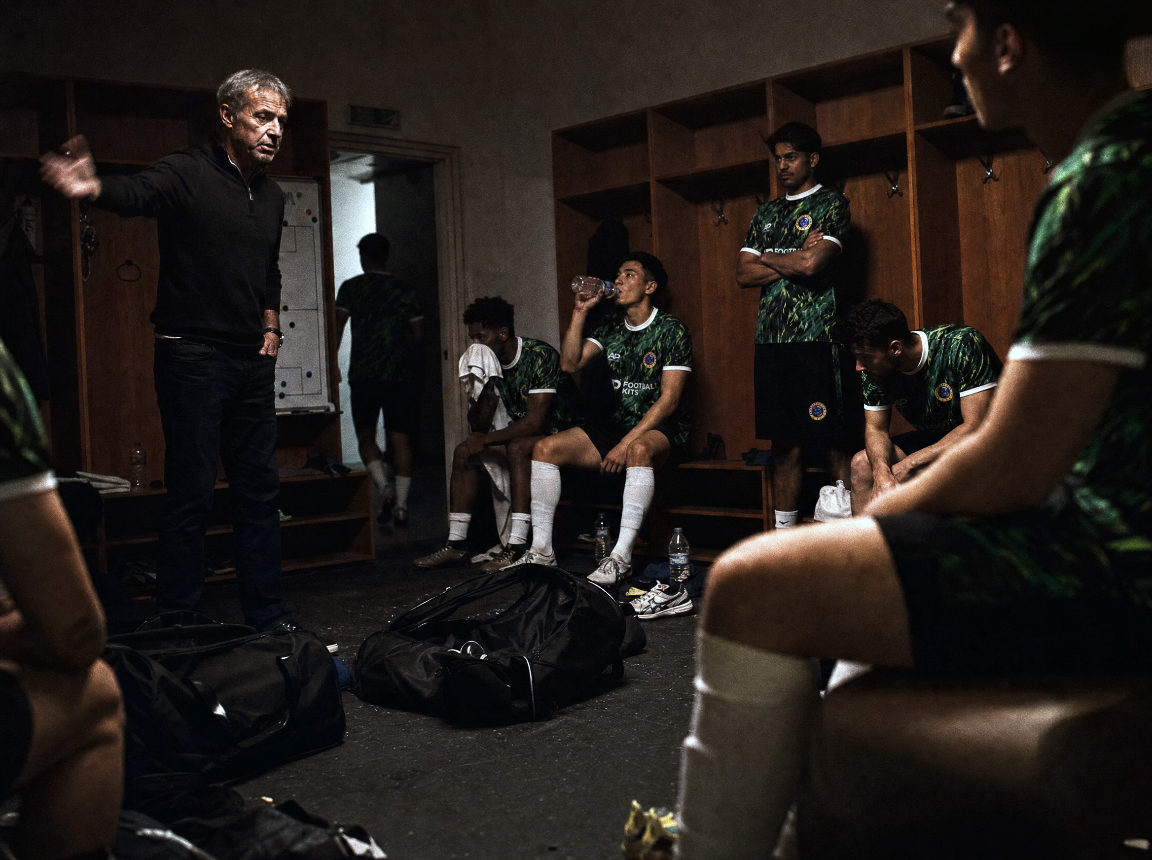 Coach talking to players in locker room